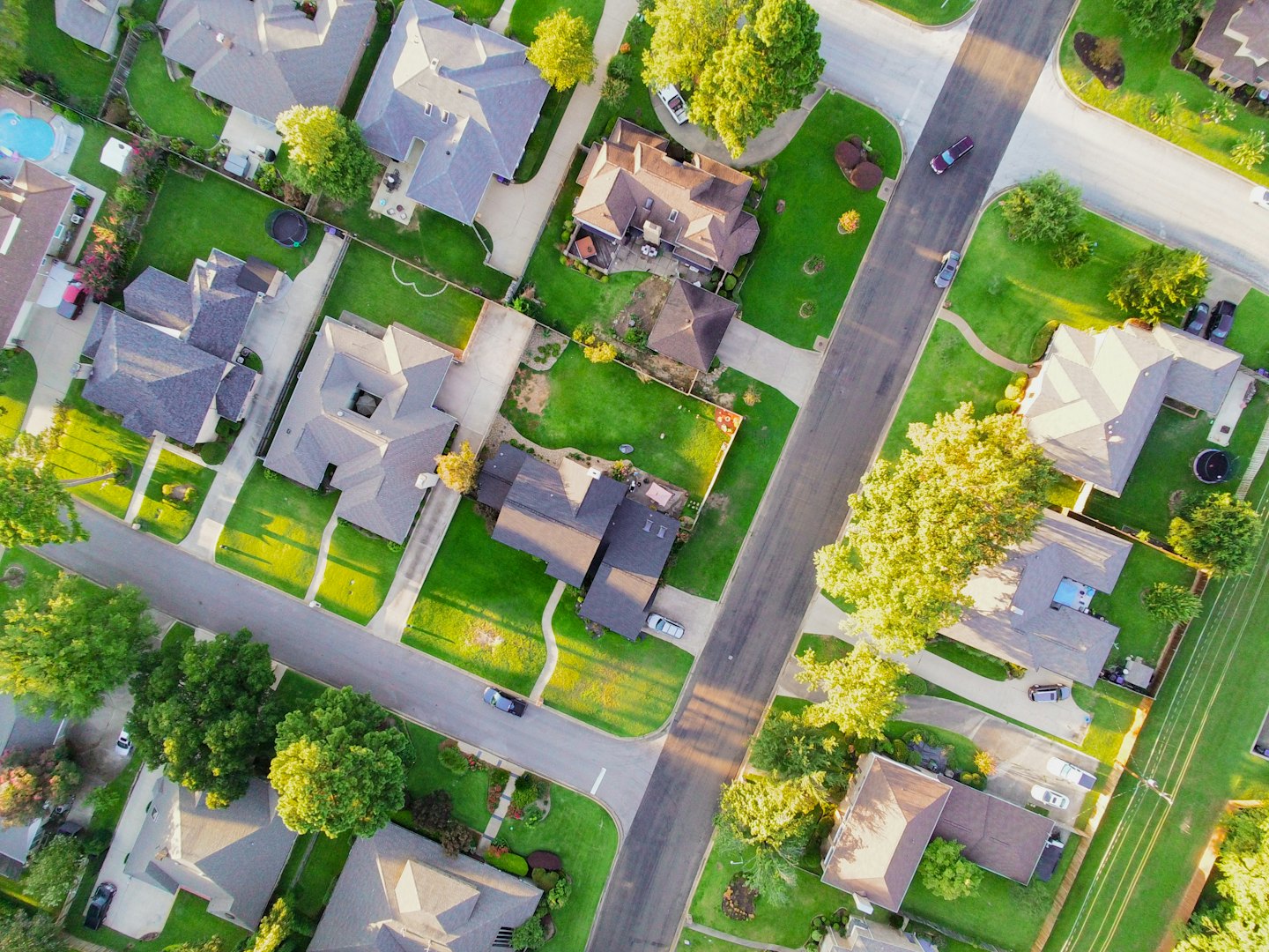 Aerial view of a dense suburban neighborhood with houses and green lawns.
