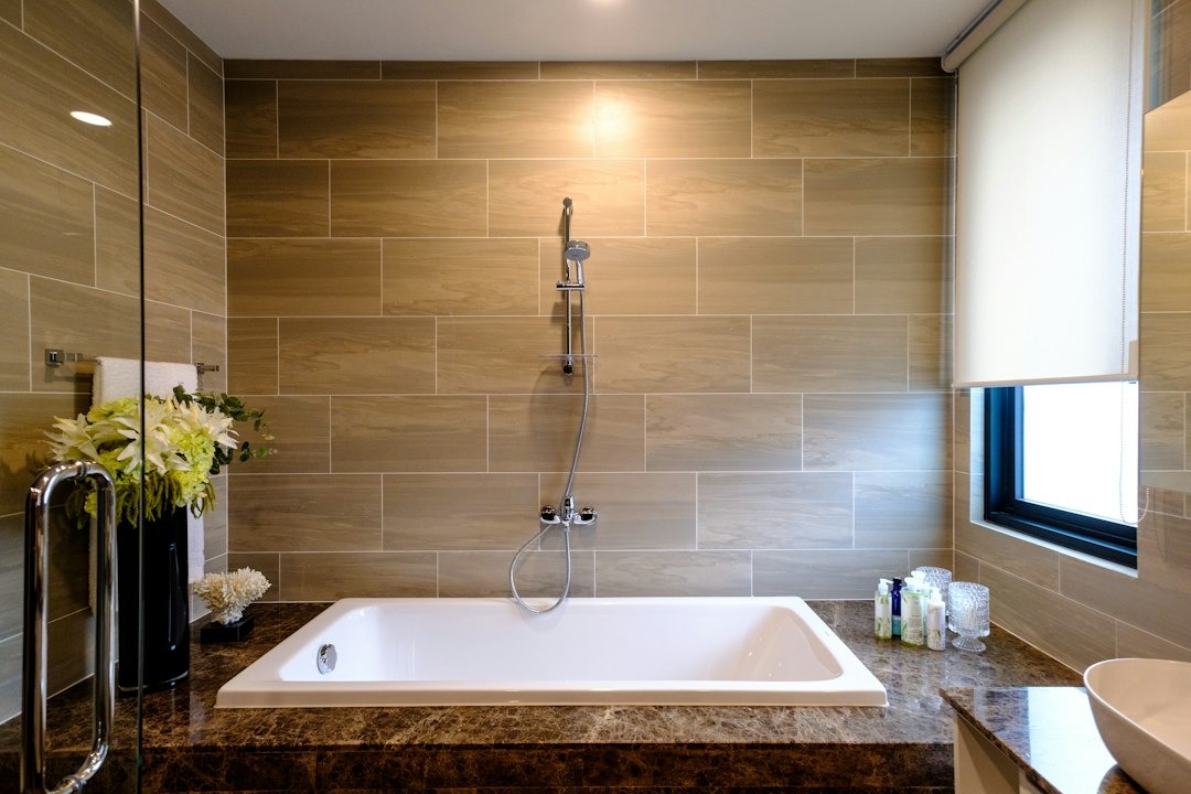 Modern bathroom with white tub and marble countertop.